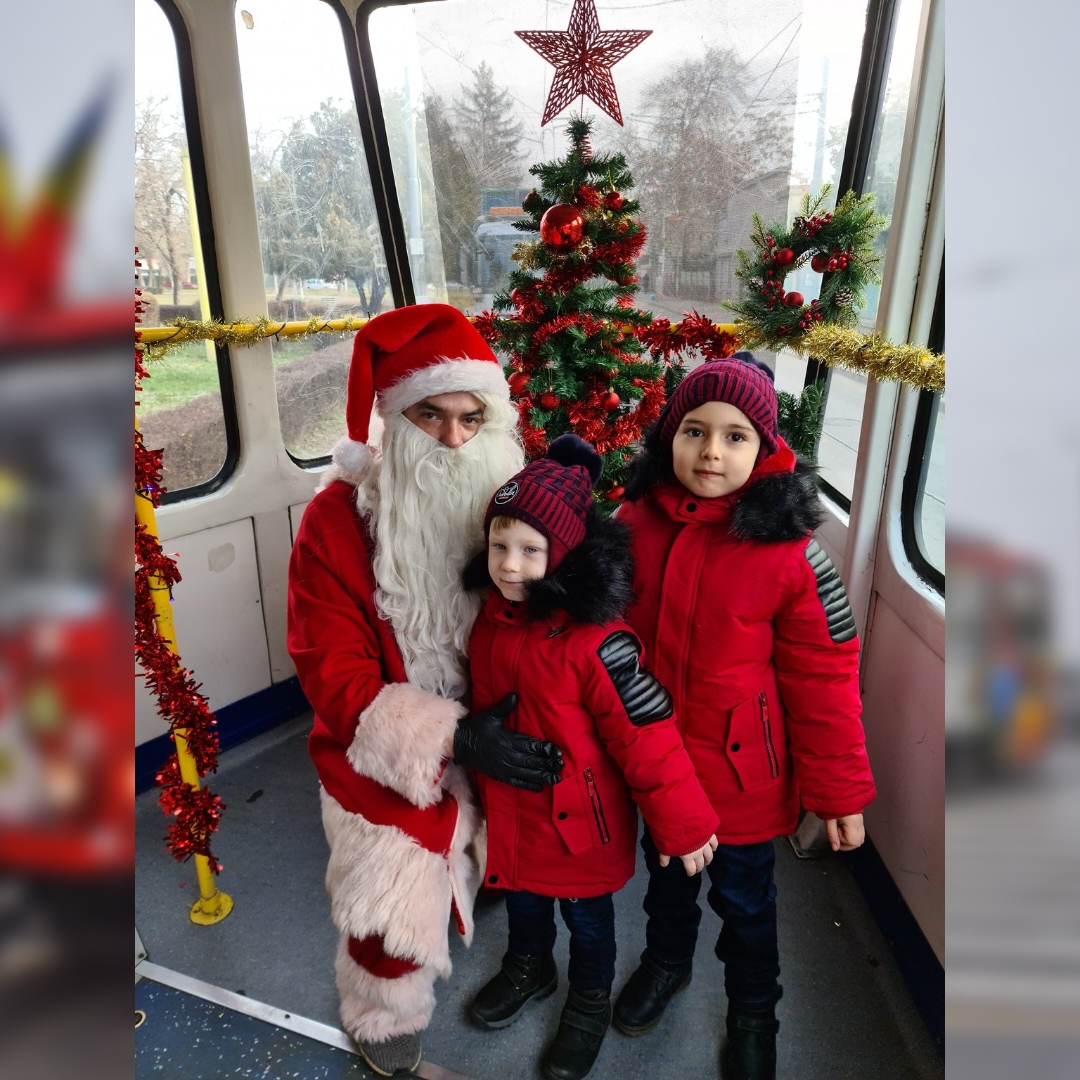 Moș Crăciun salutând copiii din tramvai